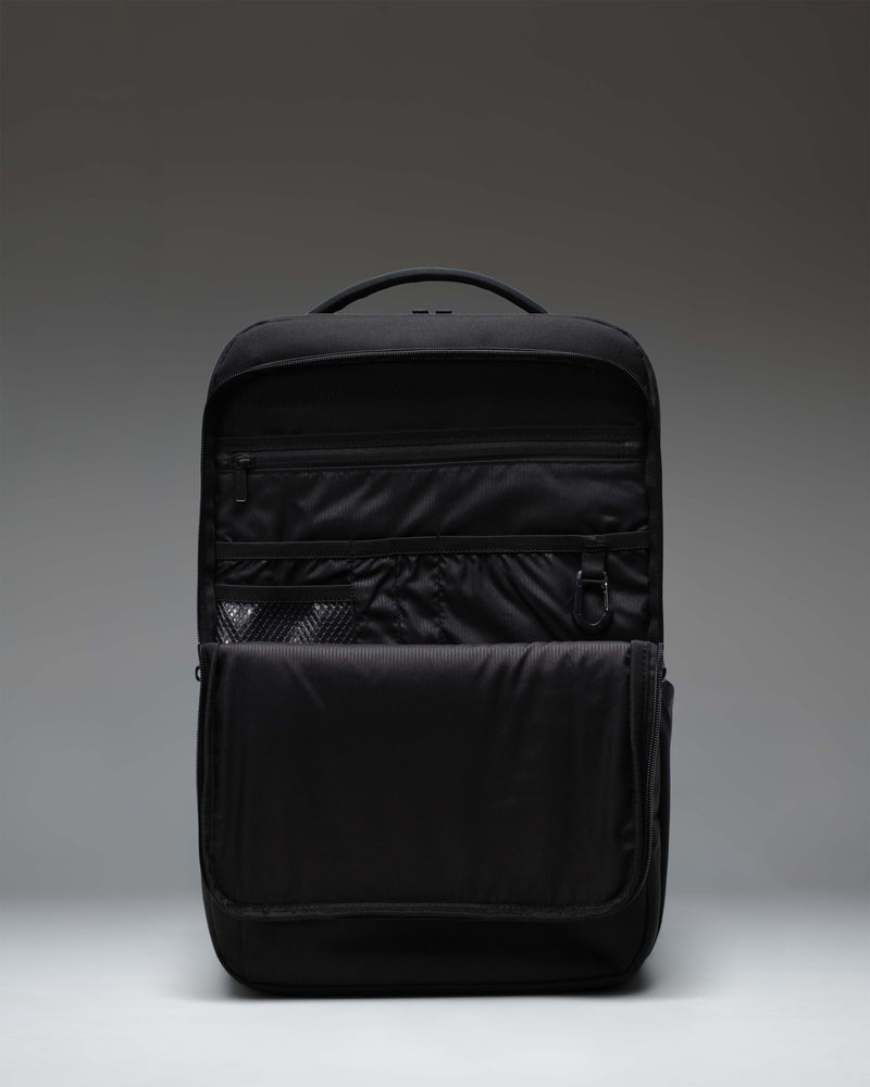 Herschel Supply Co. black Kaslo Backpack Tech shown from the side, emphasizing its sleek profile, padded shoulder straps, and mesh water bottle pocket.