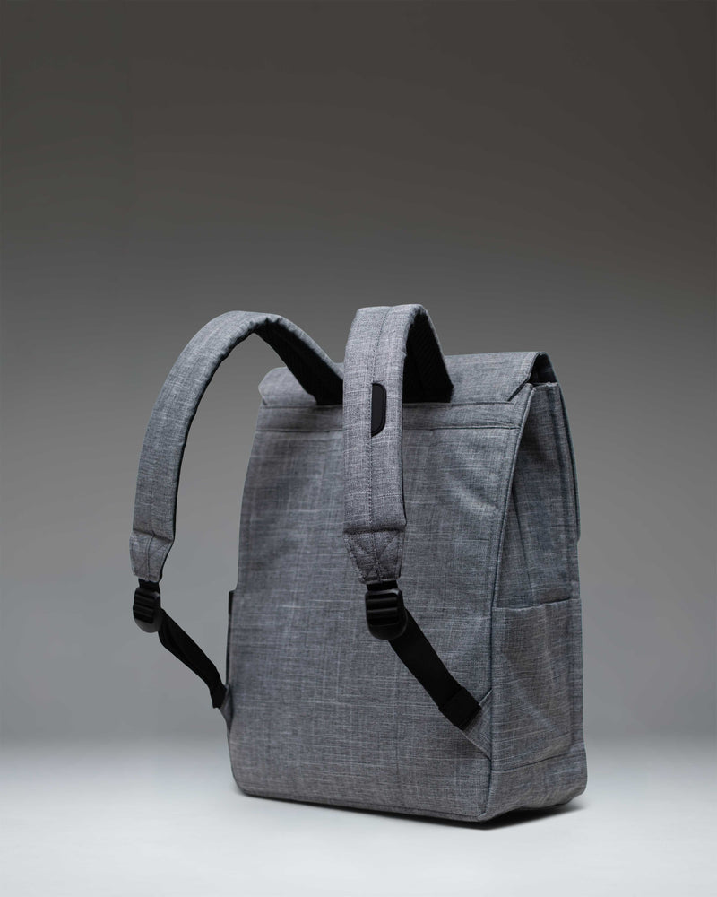 Herschel Supply Co. City Backpack in Raven Crosshatch, showing a side view of the grey backpack with a single black rubber strap closure.