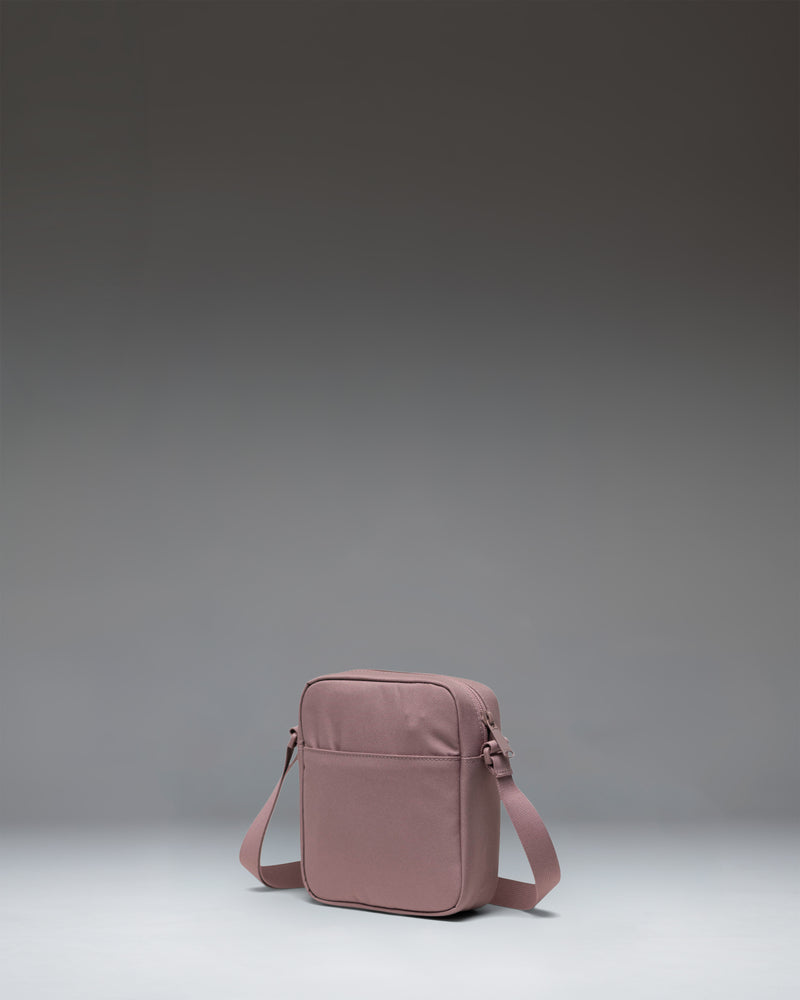 Herschel Heritage Crossbody bag in Ash Rose, showcasing its compact design, adjustable shoulder strap, and classic diamond detail.