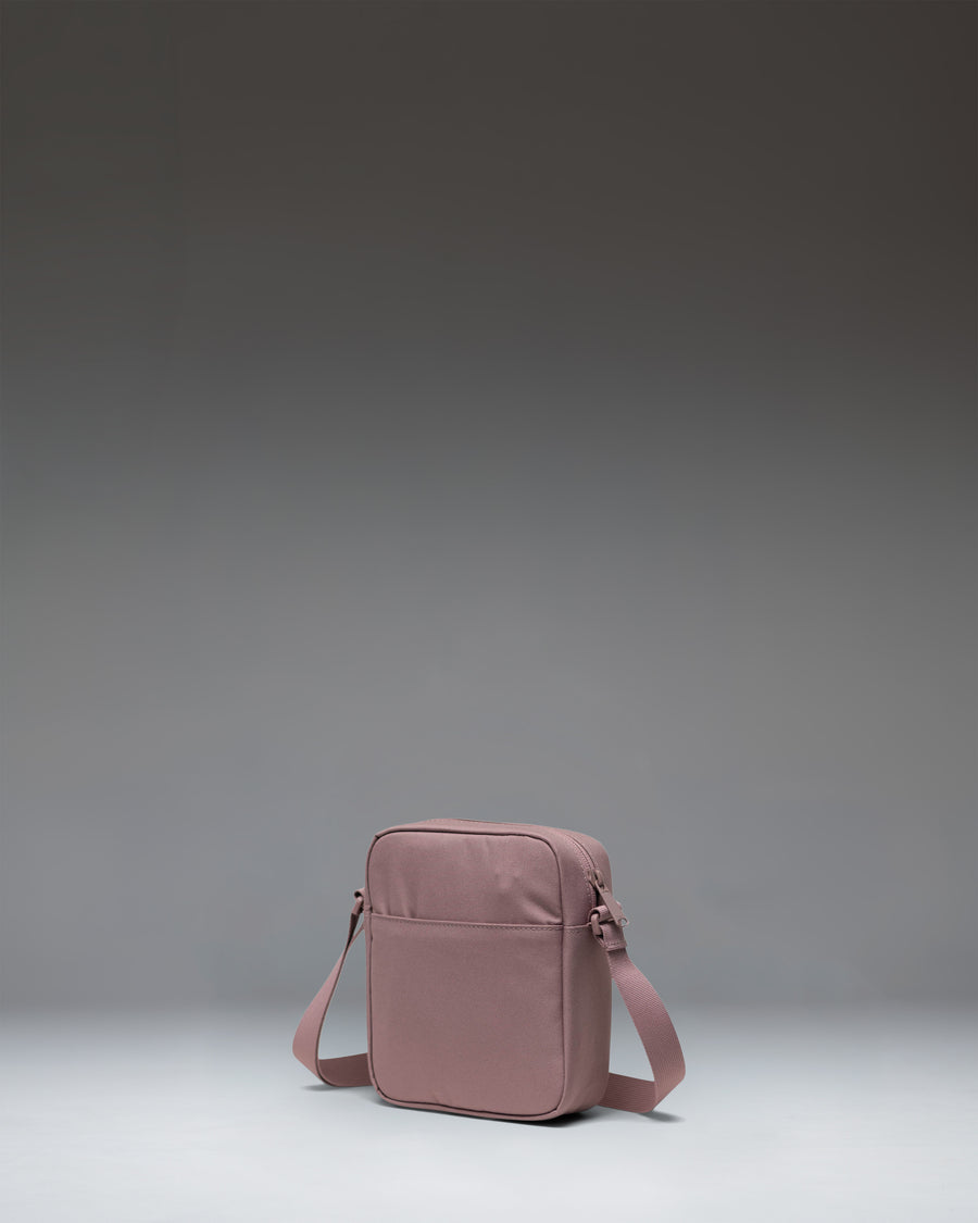 Herschel Heritage Crossbody bag in Ash Rose, showcasing its compact design, adjustable shoulder strap, and classic diamond detail.