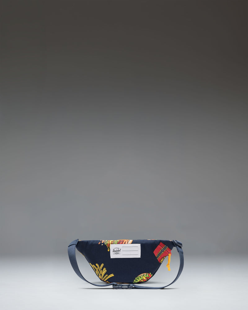 Based on the filename "11386-07201-OS_02.jpg" and the product information, this image represents the alternate view or detailed angle of the hip pack [cite: 1].

Herschel Heritage Hip Pack Little Herschel in two-tone blue and orange. Front view showing the main compartment and classic diamond accent.