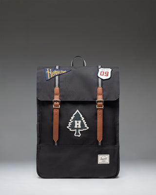 Herschel Survey Backpack in Patches Black featuring a clean rectangular design with dual straps and a subtle embroidered patch pattern.