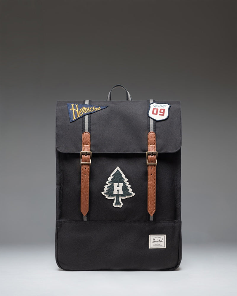 Herschel Survey Backpack in Patches Black featuring a clean rectangular design with dual straps and a subtle embroidered patch pattern.