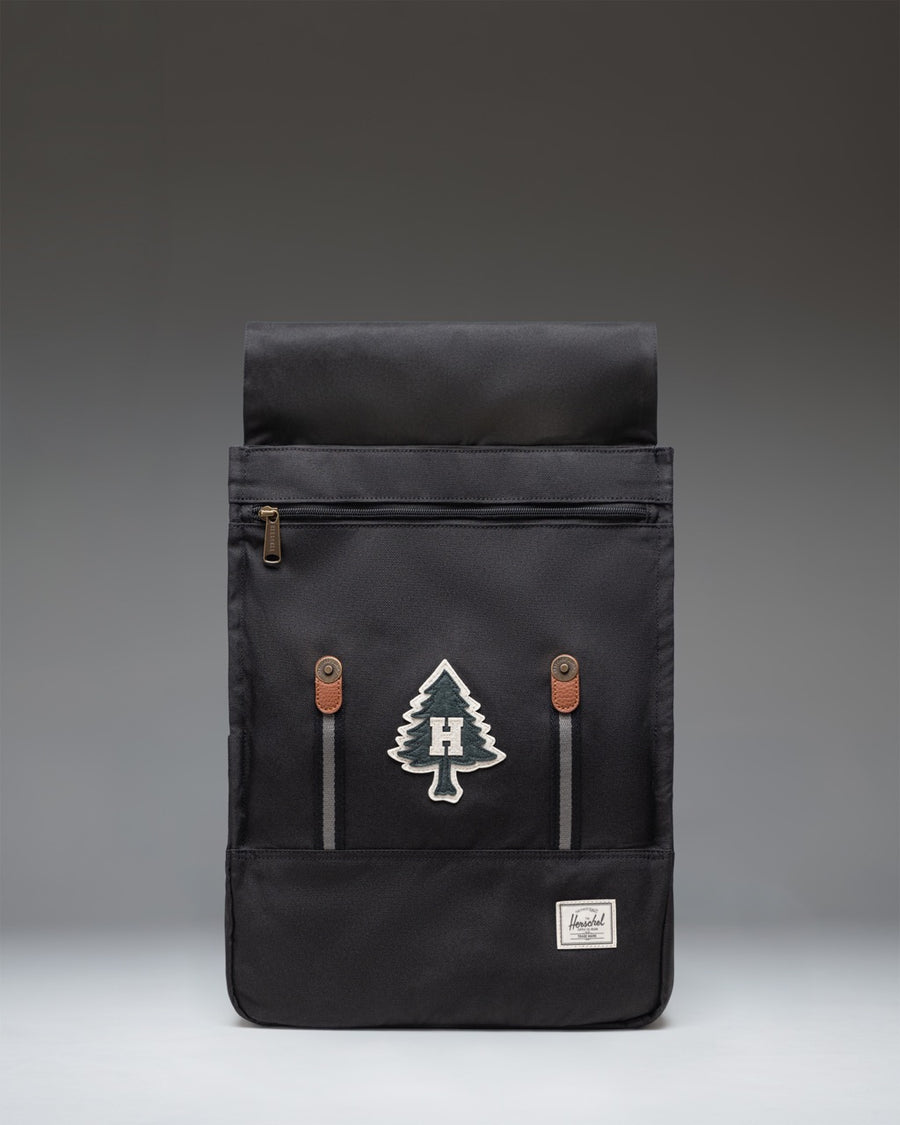 Herschel Survey Backpack in Patches Black featuring a minimalist design with a flap closure and distinctive patches.