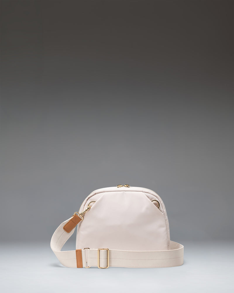Herschel Supply Co Thalia Crossbody bag in Moonbeam, showing a front view of the compact, light beige shoulder bag with a thin strap.
