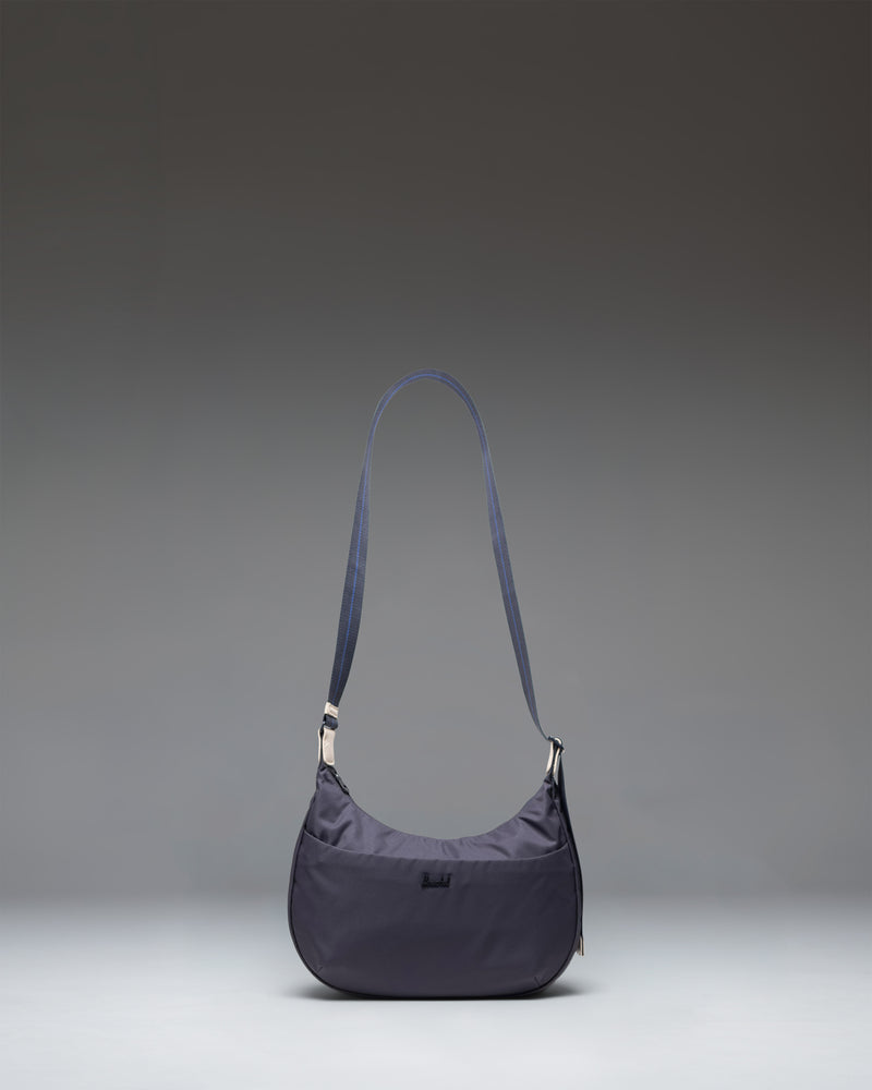 Herschel Supply Co. Yara Shoulder Bag in black showing the main compartment, zippered front pocket, and adjustable webbing strap.