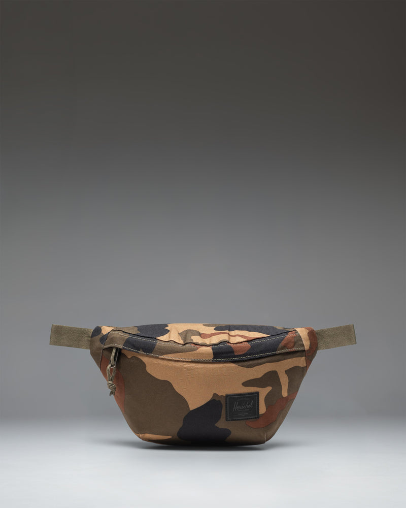 Herschel Classic Hip Pack in Woodland Camo with a black label, shown from the front against a white background.
