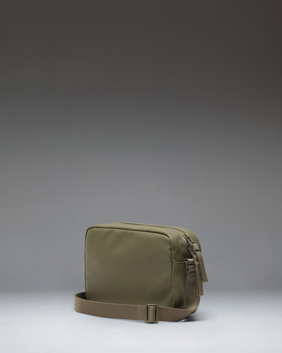 Herschel Supply Co. Alberni Crossbody bag in Ivy Green shown from the back, highlighting the adjustable shoulder strap and clean design.