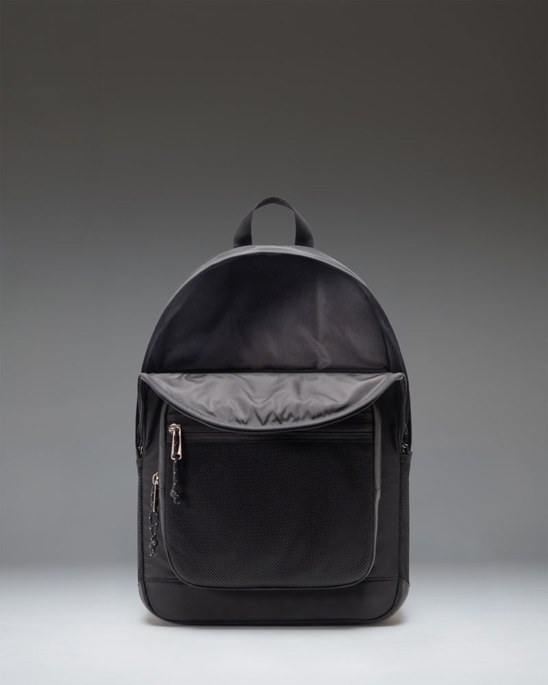 Black Herschel Supply Co. Kaine Backpack showing its utilitarian design with adjustable straps and front bungee cord detail.
