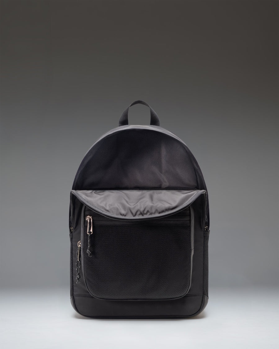 Black Herschel Supply Co. Kaine Backpack showing its utilitarian design with adjustable straps and front bungee cord detail.