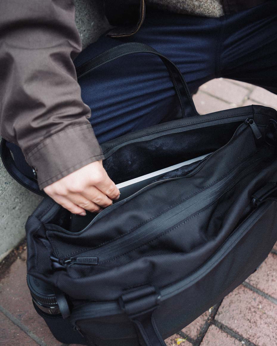 Black Herschel Kaslo Tote Tech Cordura 23L laptop and travel bag, showing its multiple compartments and trolley sleeve.