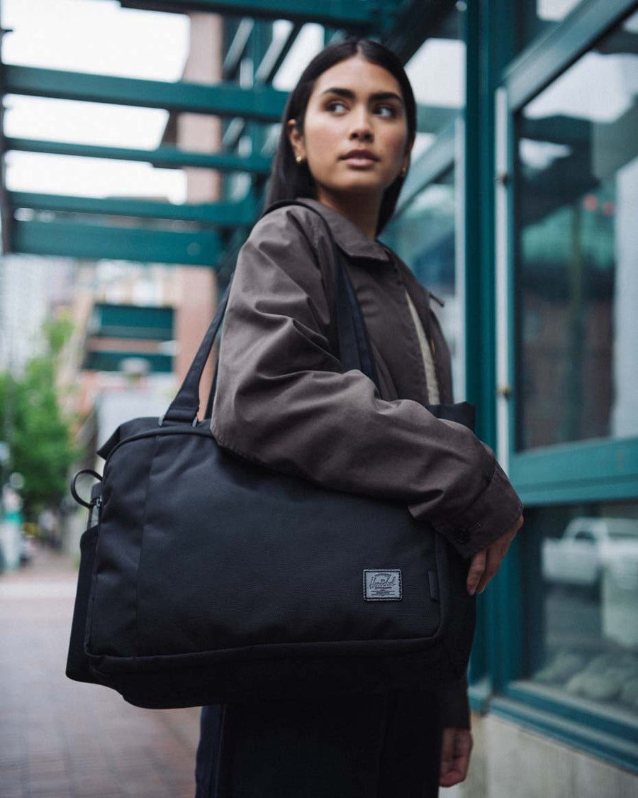Black Herschel Kaslo Tote Tech Cordura bag showing multiple color variants available.