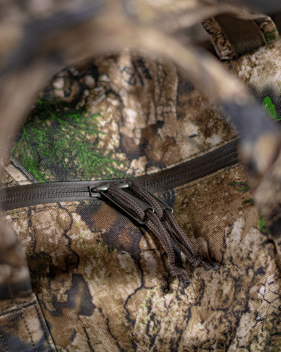 Herschel Supply Co. Novel Duffle bag in Realtree APX Camo pattern, featuring a rugged wilderness-inspired camouflage print.