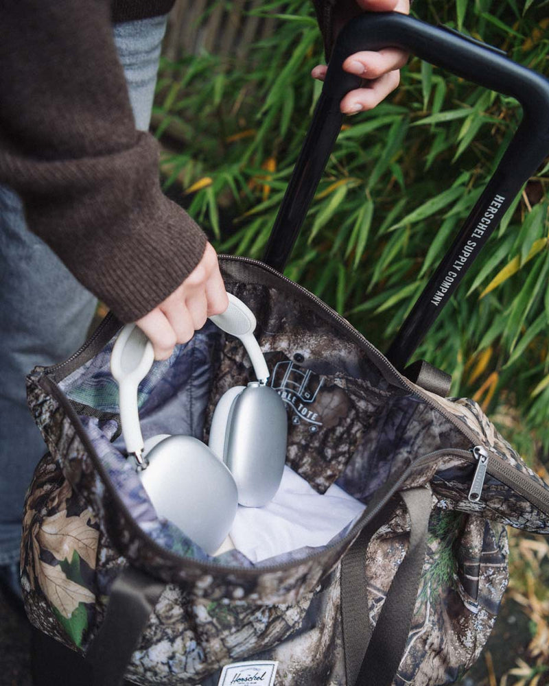 Herschel Supply Co. Realtree Portland Packable Tote bags displayed in a lineup of various available colors.