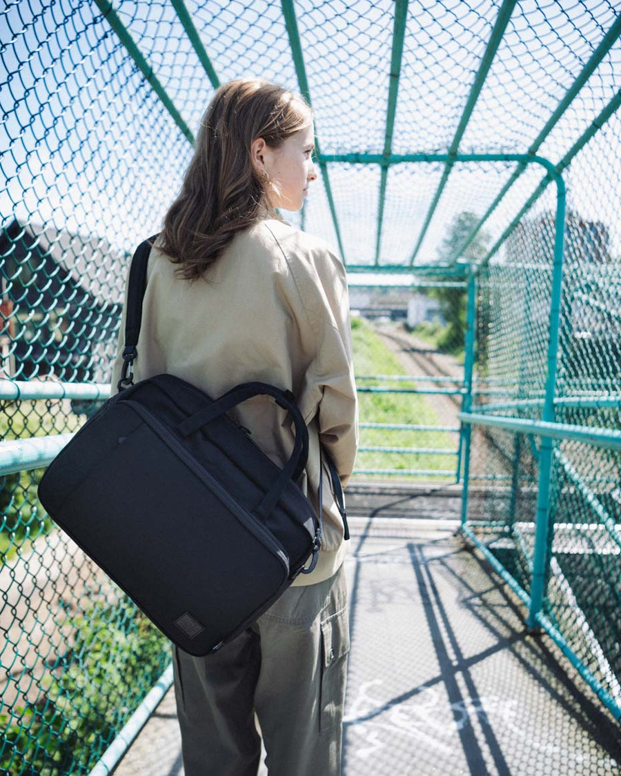 Herschel Supply Co. Gibson Messenger Tech Cordura 18L laptop messenger bag in black, showing compartments and organization features.