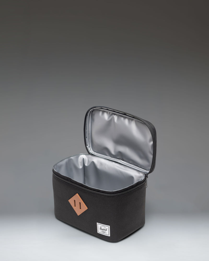 Black Herschel Heritage Lunch Box shown from the front, highlighting its classic design, zippered main compartment, and front sleeve pocket.