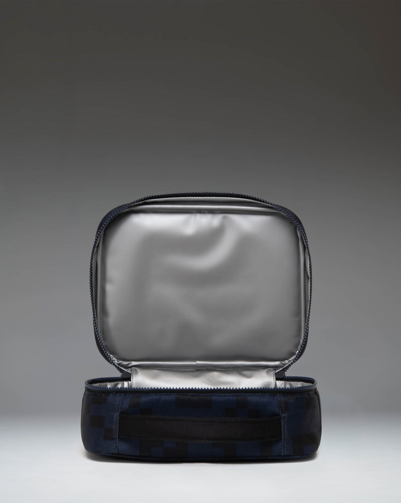 Herschel Supply Co. Minecraft Pop Quiz Enderman lunch box, lifestyle view showing its compact design and pixelated print.