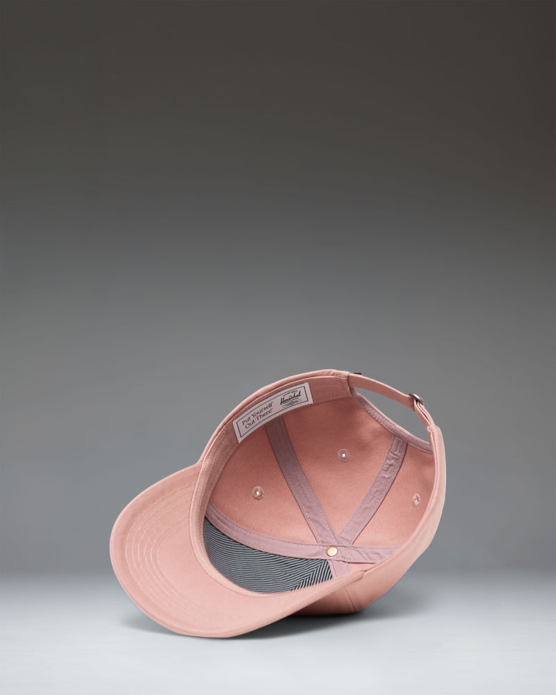 Herschel Supply Co. Sylas Classic Cap in Ash Rose, a light pink adjustable baseball hat shown from the side view.