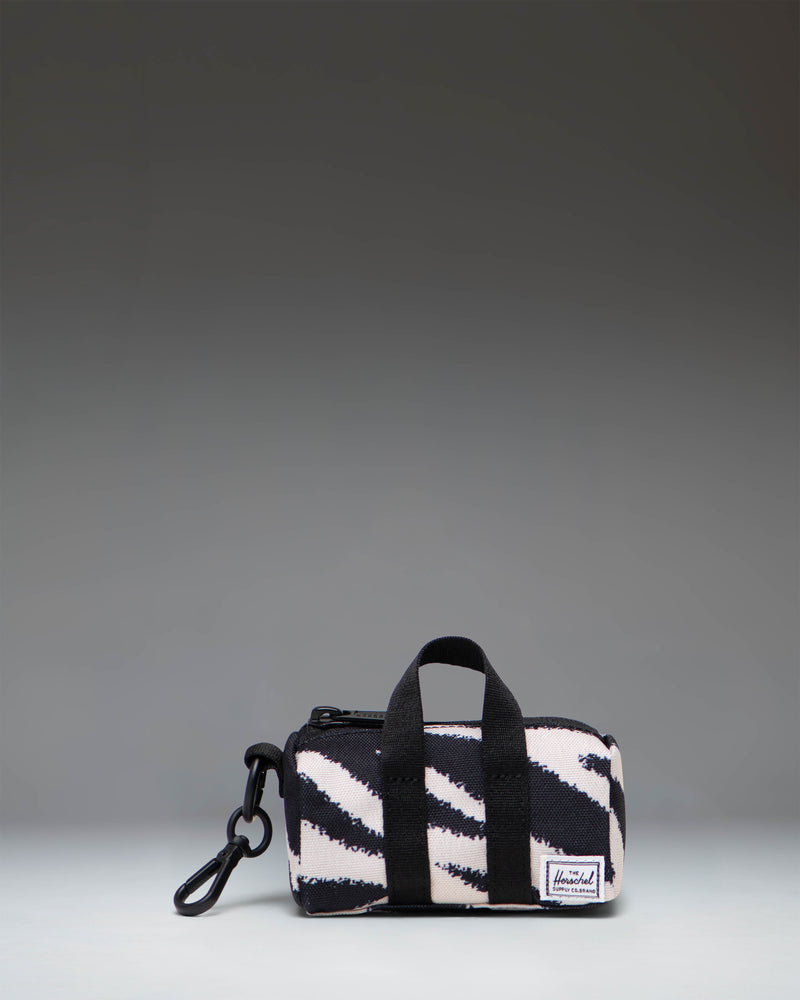 Herschel Novel Duffle Bag Charm in black and white zebra print with a top handle, zippered main compartment, and signature shoe compartment.