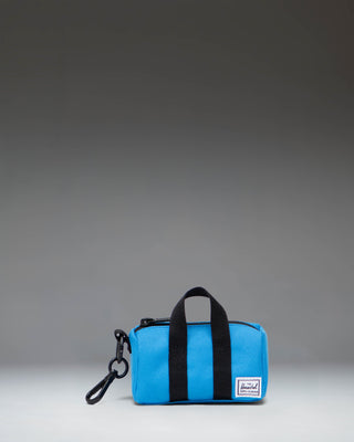 Herschel Novel Duffle Bag Charm in French Blue, featuring a miniature duffle bag design with a zipper and top handles.