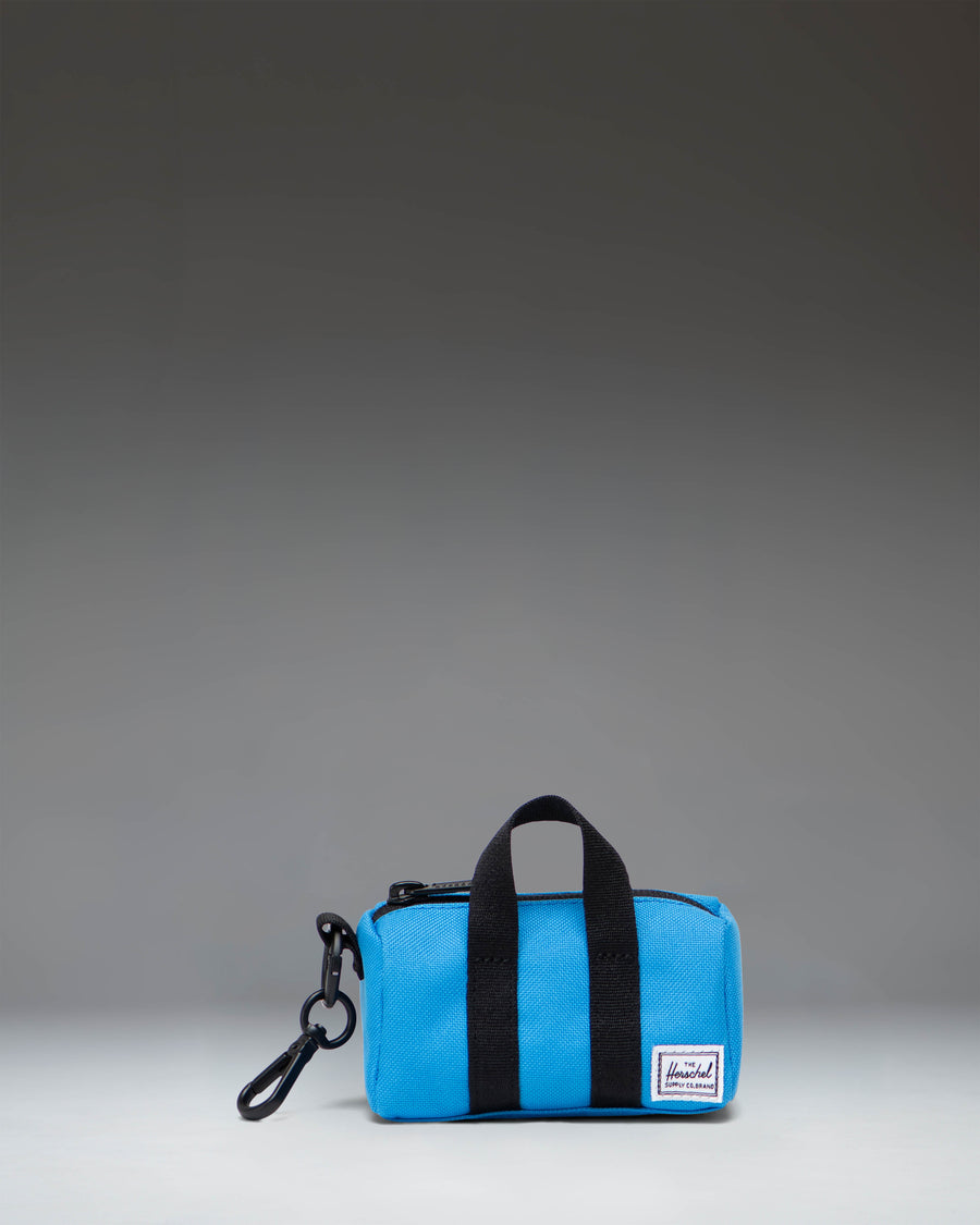 Herschel Novel Duffle Bag Charm in French Blue, featuring a miniature duffle bag design with a zipper and top handles.