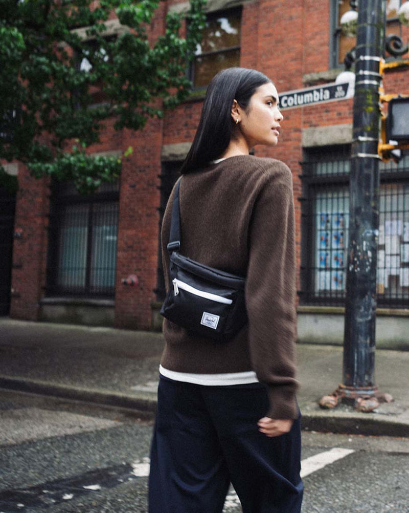 Herschel Supply Co. Pop Quiz Hip Pack in black shown on a mobile device screen.