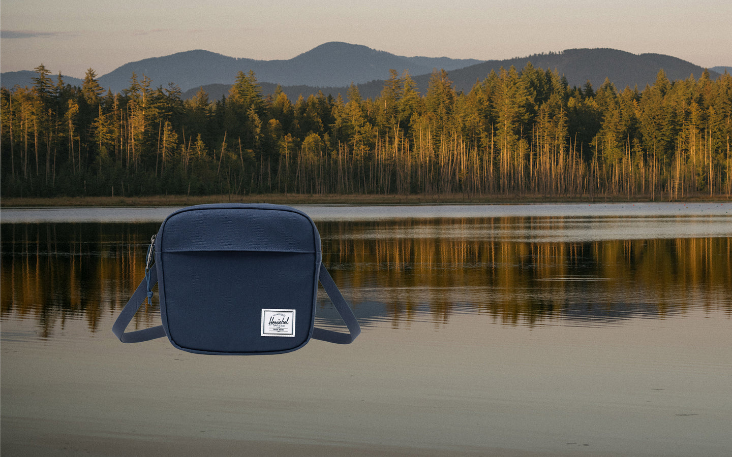 Navy Herschel Classic Crossbody bag shown on a desktop display.