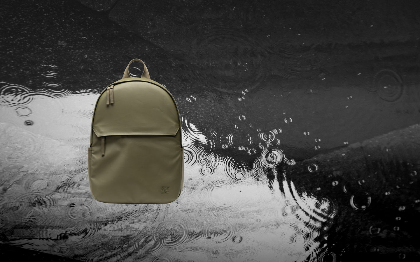 Herschel Supply Co Alberni Backpack in Ivy Green shown from the front on a desktop background display.