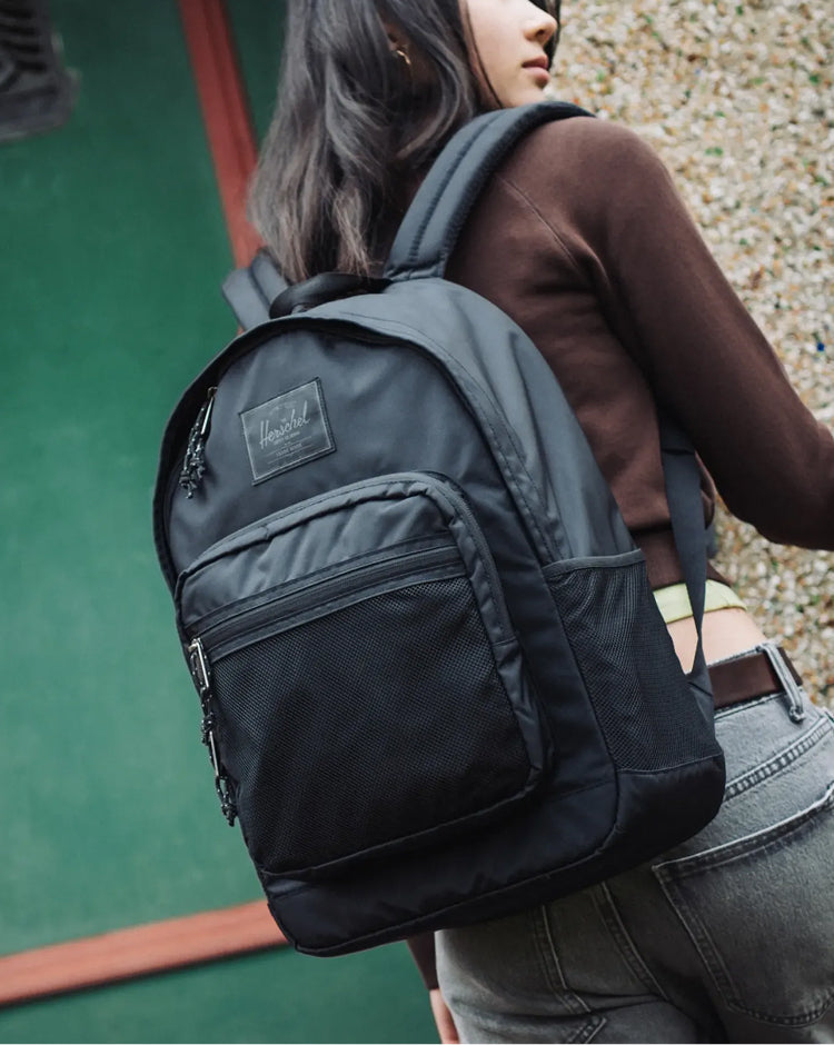 Herschel Supply Co. Kaine Backpack in solid black, showing a front view with shoulder straps and front pockets on a white background.