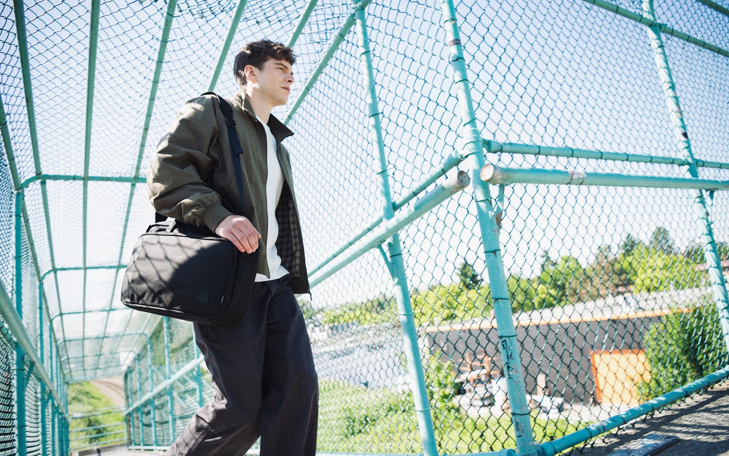 Herschel Supply Co. Gibson Messenger Tech Cordura in Black. Front view of the durable messenger bag with carrying handles and shoulder strap.