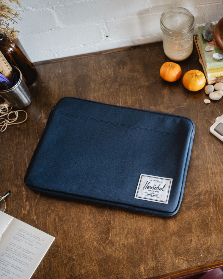 Navy Herschel Supply Co. Anchor 14-inch laptop sleeve, showcasing a clean and durable padded design.