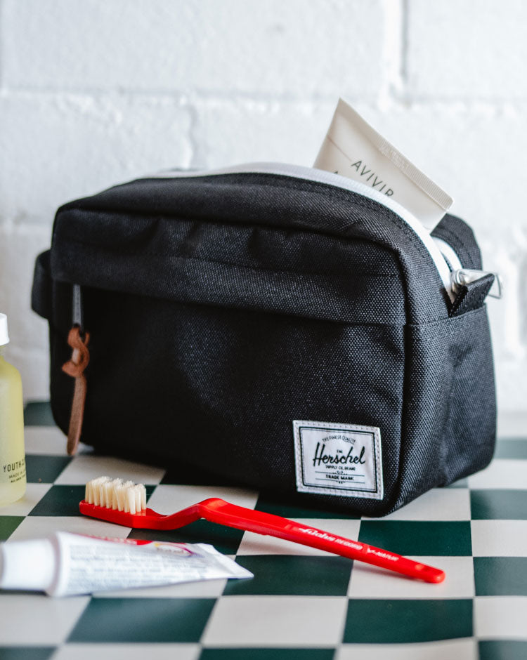 Herschel Supply Co Chapter Small Travel Kit in black, featuring a side carrying handle and a front zippered pocket.