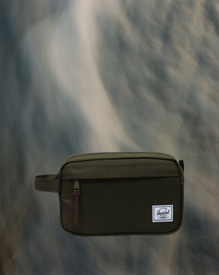 Herschel Supply Co. Chapter Travel Kit in Ivy Green, a compact travel toiletry bag featuring a front zip pocket and a side carrying handle.