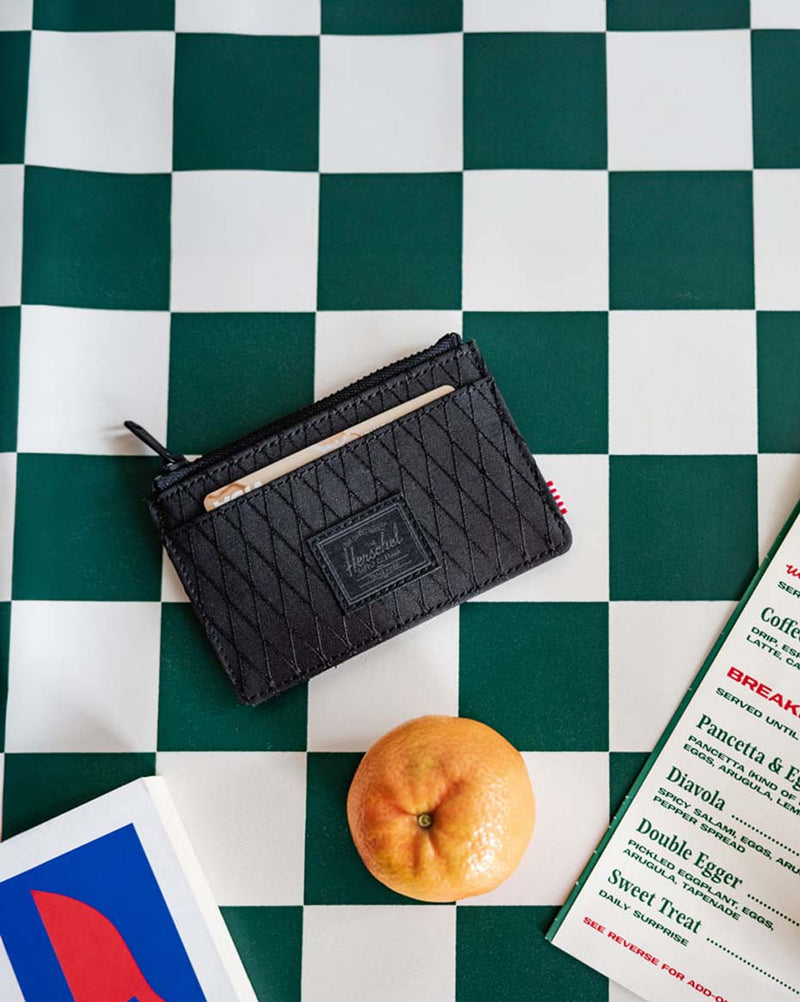 Close-up of a Herschel Supply Co. Oscar Cardholder in Black Diamond/Black featuring a textured geometric pattern and a classic logo tab.