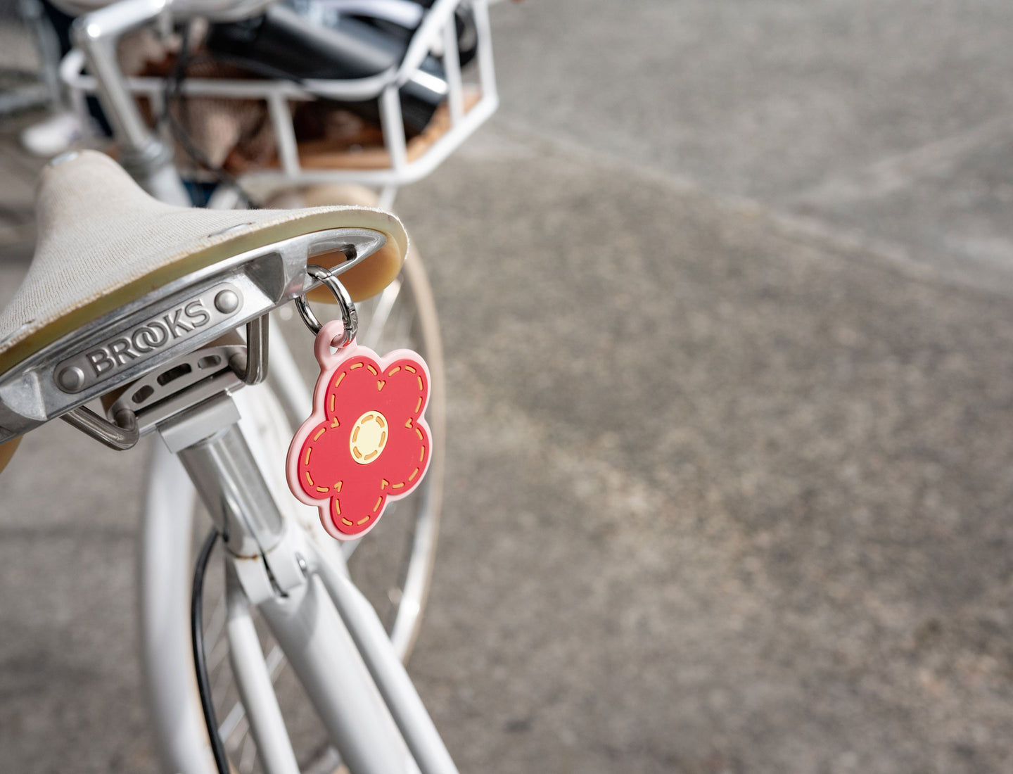 Herschel Supply Co. Daisy Bag Charm in Pink Daisy featuring a white flower with a yellow center and a pink carabiner clip.