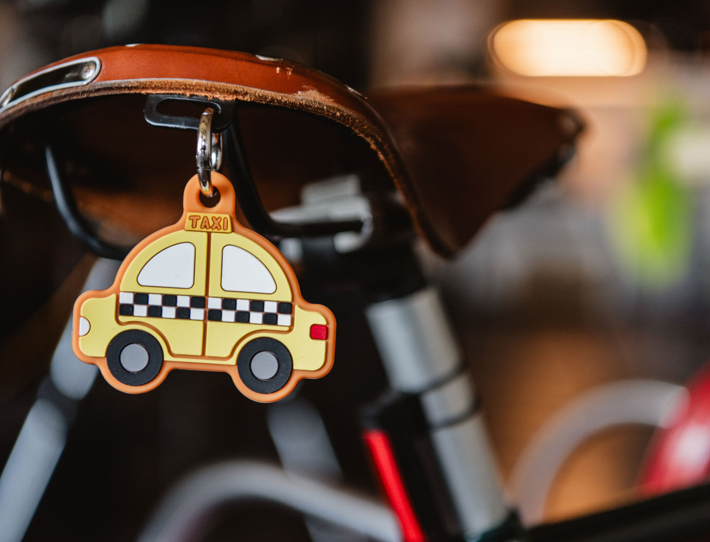 Yellow vintage-style taxi bag charm by Herschel Supply Co with checkered patterns and black wheels.