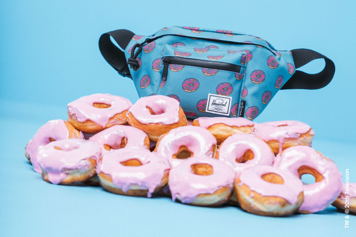 The Homer Simpson Seventeen Hip Pack on a stack on donuts from The Simpsons™ x Herschel Supply Company collection