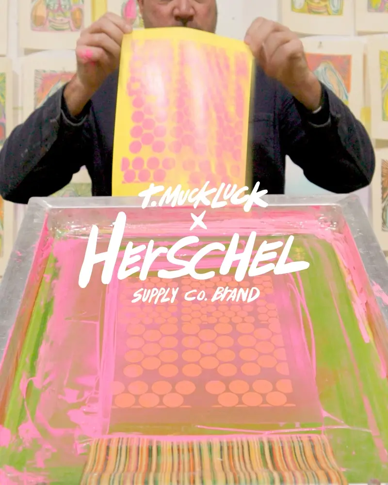 An image of a man standing in the rain, waiting for a bus, wearing a black Herschel Alberni Weather Resistant Backpack 